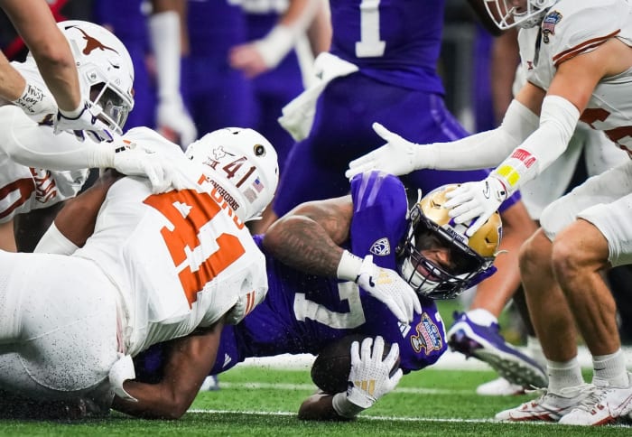 Texas Longhorns linebacker Jaylan Ford (41) brings down Washington Huskies running back Dillon Johnson (7) in the second quarter of the Sugar Bowl College Football Playoff semi-finals at the Ceasars Superdome in New Orleans, Louisiana, Jan. 1, 2024. The Texas Longhorns take on the Washington Huskies for a spot in the College Football Playoff Finals.